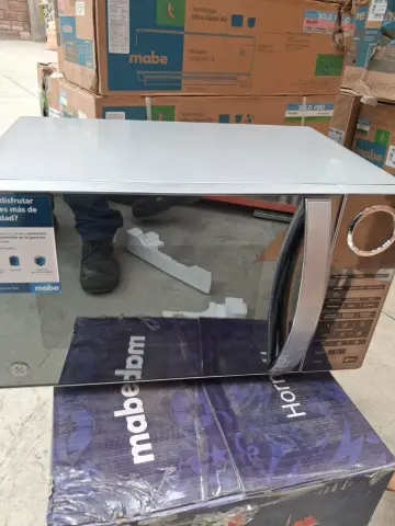 Microondas Mabe — Presenta un hundimiento/abolladura en la esquina posterior superior izquierda de la cubierta metálica superior.