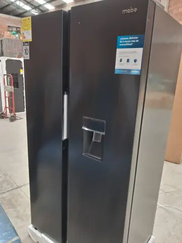 Nevecon mabe 565L — Abolladura en el panel lateral superior izquierdo de la puerta