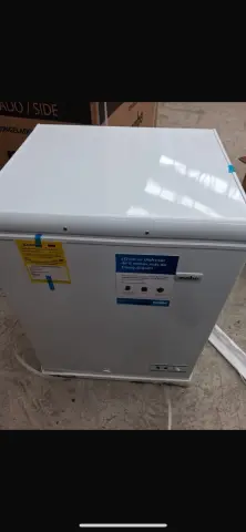 Congelador #1 — Leve abolladura en el panel lateral y fisuras menores en las rejillas inferiores de ventilación trasera